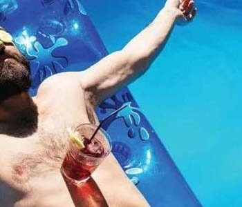 man in pool with drink