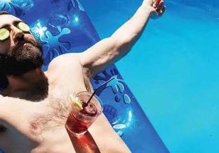 man in pool with drink