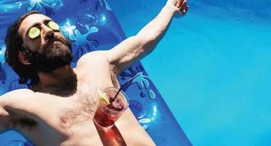 man in pool with drink